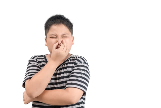 Boy holding his nose